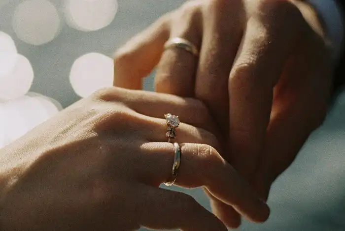 a married couple touching hands.